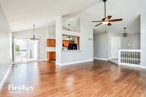 St Charles house for rent - an empty living room with wood floors and a ceiling fan