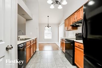 St Charles house for rent - a kitchen with wood cabinets and black appliances and white tile floors