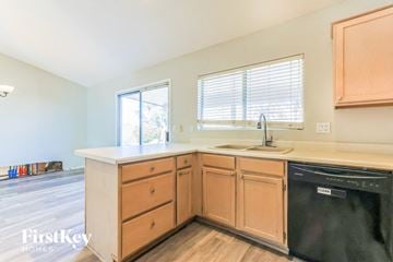Chandler house for rent - a kitchen with wooden cabinets and a sink and a dishwasher