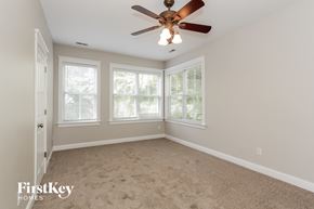 Huntersville house for rent - a bedroom with a ceiling fan and three windows