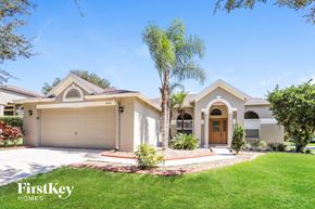 Valrico house for rent - a house with a garage and a palm tree in the yard