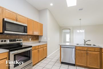 Valrico house for rent - a kitchen with wooden cabinets and stainless steel appliances