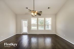 Katy house for rent - A room with a ceiling fan and wooden floors.
