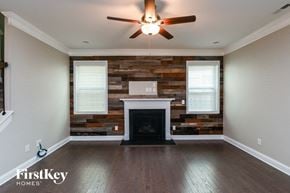 Huntersville house for rent - an empty living room with a fireplace and a reclaimed wood wall