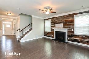 Huntersville house for rent - an empty living room with a fireplace and a staircase