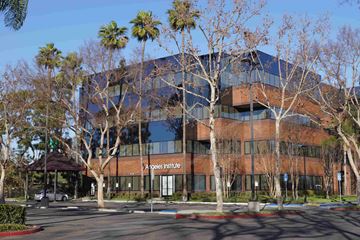 Artesia apartment for rent - The Angeles Institute is a large, modern building with a glass facade and a brown roof.
