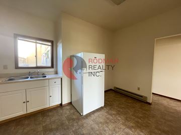Longview apartment for rent - A kitchen area with a sink, cabinets, and a refrigerator.