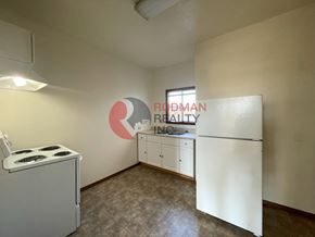 Longview apartment for rent - A small, empty room with a gas stove and a refrigerator.