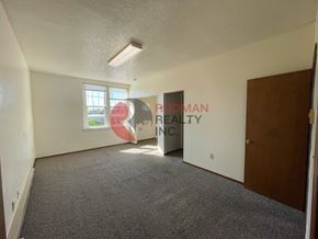Longview apartment for rent - A room with a carpet floor and a window letting in sunlight.