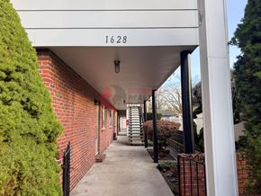 Longview apartment for rent - A long white covered walkway with a number 1628 on the wall.