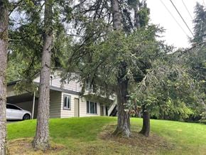 Kelso apartment for rent - A house with a car parked in front and trees surrounding it.