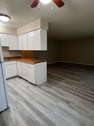 Kelso apartment for rent - A kitchen with white cabinets and a wooden countertop.