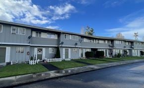 Longview apartment for rent - A row of grey houses with white fences in front.