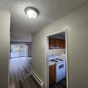 Longview apartment for rent - A small kitchen with a white stove and wooden cabinets.