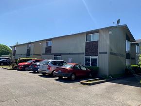 Kelso apartment for rent - A parking lot with several cars parked in front of a building.