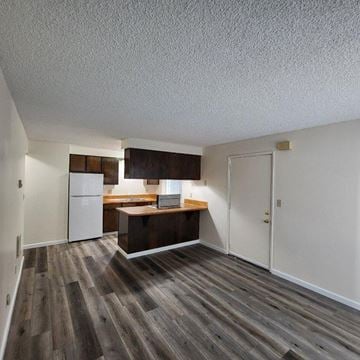 Kelso apartment for rent - A kitchen with a white refrigerator and wooden cabinets.