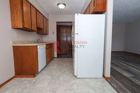 Longview apartment for rent - A kitchen with a white fridge and wooden cabinets.