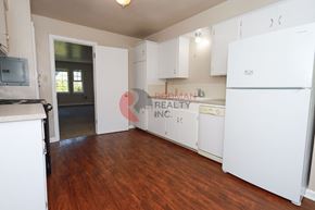 Longview apartment for rent - A kitchen with white appliances and wooden floors.