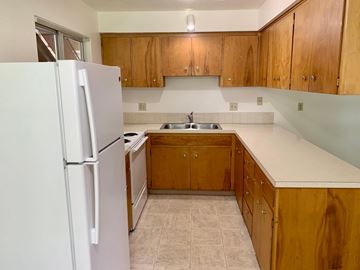 Longview apartment for rent - A kitchen with wooden cabinets and a white refrigerator.