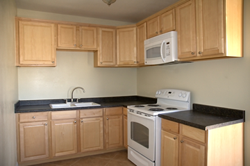 Glendora apartment for rent - an empty kitchen with white appliances and wooden cabinets
