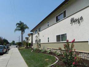 West Covina apartment for rent - a white building with a sign on the side of a sidewalk