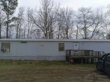 Beech Island house for rent - A white building with a porch and a car parked in front.