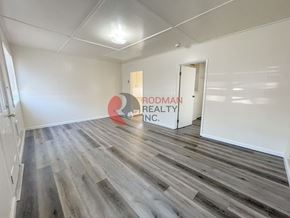 Kelso apartment for rent - A room with wooden flooring and a sign that says "Rodman Realty Inc.".
