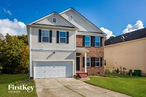 Charlotte house for rent - a house with a white garage door and a brick house