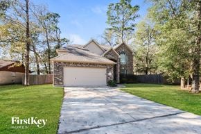 Crosby house for rent - a garage with a white driveway and a brick house