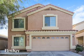 Buckeye house for rent - a tan brick house with a garage door