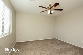 Buckeye house for rent - a bedroom with a ceiling fan and a carpet