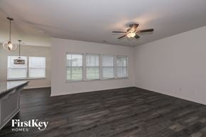 Monroe house for rent - A spacious room with a ceiling fan and wooden flooring.