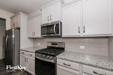 Monroe house for rent - A kitchen with a stove top oven and a microwave above it.