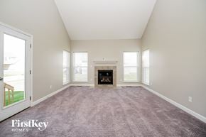 Reynoldsburg house for rent - A large, empty room with a fireplace in the middle.
