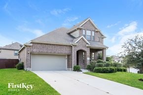 Conroe house for rent - a brick house with a garage and a white driveway