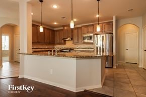 Conroe house for rent - a kitchen with a large island and a stainless steel refrigerator