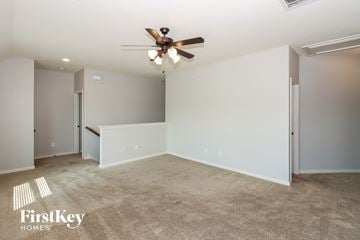 Conroe house for rent - a living room with carpet and a ceiling fan