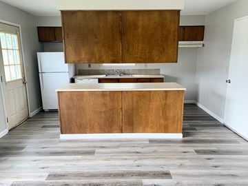 Longview house for rent - an empty kitchen with wooden cabinets and a white refrigerator