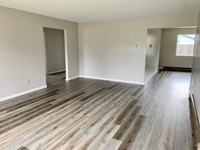 Longview house for rent - the living room and dining room of an empty home with wood flooring