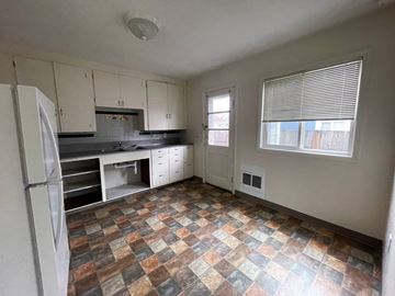 Castle Rock apartment for rent - an empty kitchen with a refrigerator and a window