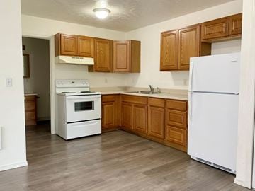 Castle Rock apartment for rent - A kitchen with wooden cabinets and white appliances.
