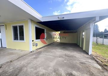 Longview house for rent - A building with a yellow exterior and a sign that reads "Brookman Realty Inc." is shown.