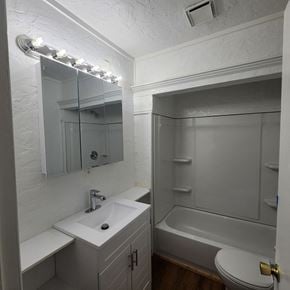 Longview house for rent - A white bathroom with a sink, mirror, and toilet.