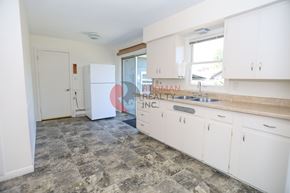 Longview house for rent - A kitchen with white cabinets and a stone floor.