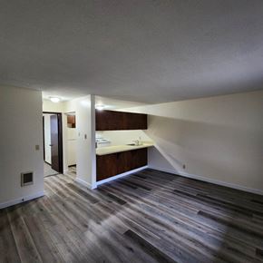 Longview apartment for rent - A room with a kitchen area and a wood floor.