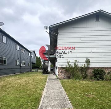 Longview apartment for rent - A building with the words "Prodman Realty Inc." painted on it.