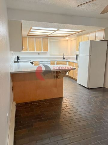 Longview house for rent - A kitchen with a white refrigerator and wooden cabinets.