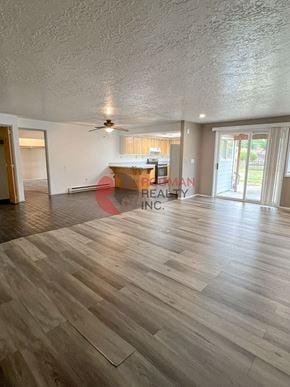 Longview house for rent - A spacious room with wooden flooring and a ceiling fan.