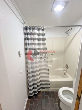 Longview house for rent - A bathroom with a shower curtain that has the words "BRODMAN REALTY INC." on it.