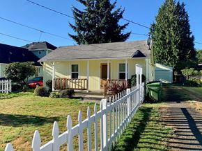 Longview house for rent - a small yellow house with a white picket fence